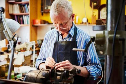 A clock maker busy in his workshop. Foto stock