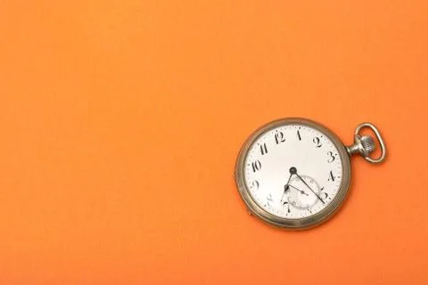 Clock on an orange surface - time management concept 스톡 사진