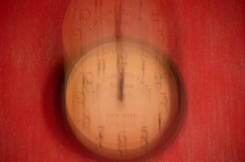 The clock is out of focus on a red background. Running time. Stock Photos