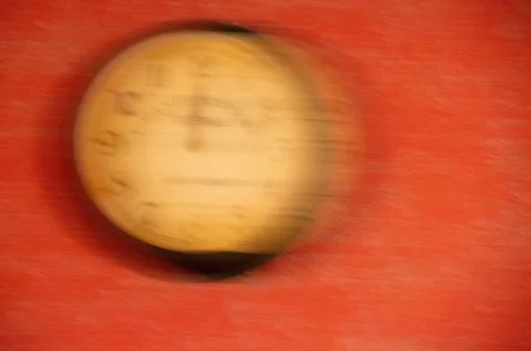 The clock is out of focus on a red background. Running time. Stock Photos