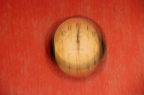 The clock is out of focus on a red background. Running time. Stock Photos