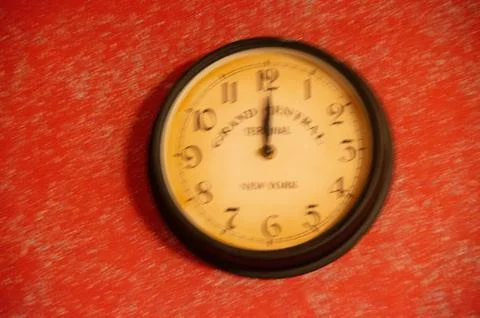 The clock is out of focus on a red background. Running time. Stock Photos