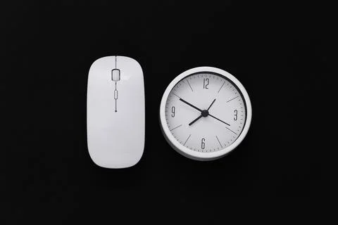 Clock with pc mouse on a black background. Working Deadline. Top view. 库存照片