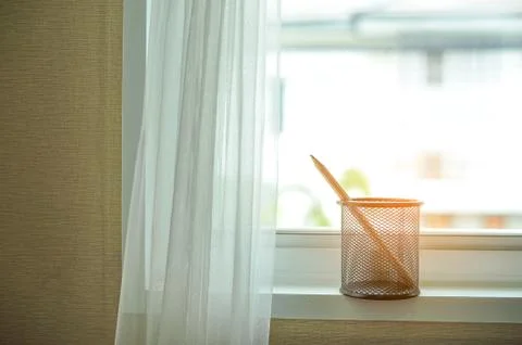 Clock with pencil by the window 스톡 사진