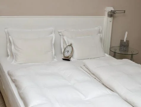 Clock on Pillows on a Bed Stock Photos