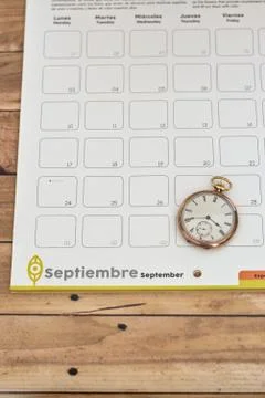 Clock on a planner on a wooden table - time management concept Stock Photos