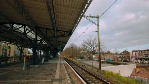 Clock at railway platform under historic Dutch station roof Empty tilt down to Stock Footage 296262647