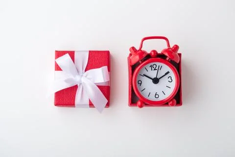 Clock in red gift box on white background, time concept Stock Photos