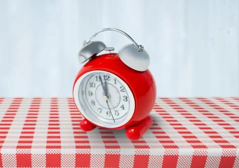 Clock on red tablecloth 스톡 사진