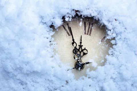 A clock with Roman numerals in the snow. Stock Photos