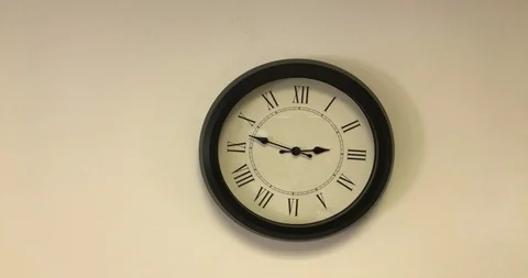 Clock with roman numerals on the white wall at about 14:50 Vidéo 104990452