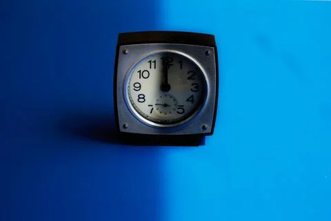 Clock with a shadow on the dial at noon, confusing day and night, light and d Stock Photos