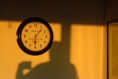 Clock with shadow on wall Stock Photos