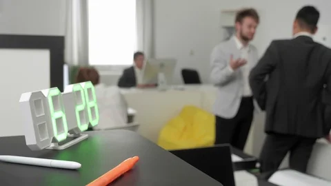 Clock is on the shelf, on the backgorund there are office workers. Stock Footage 116623680