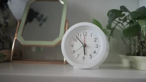Clock shows time in a room with plants and a mirror 動画素材 341456565