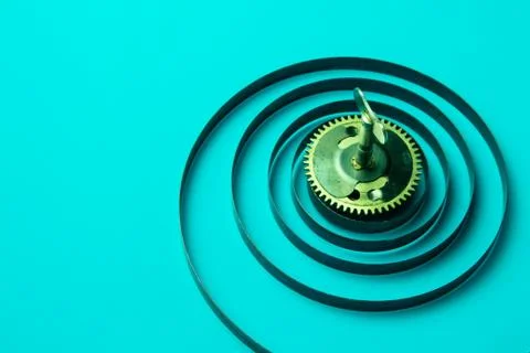 Clock spring with gear on a blue background, metal spiral Stock Photos