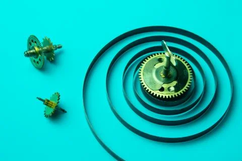 Clock spring with gears on a blue background, metal spiral Stock Photos