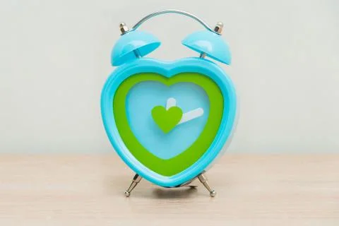Clock standing on a wooden background Stock Photos