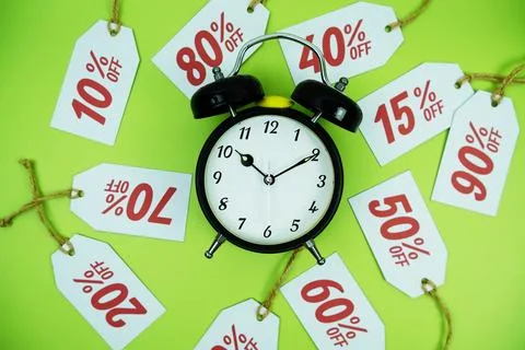 Clock surrounded by various discount tags with percentages like 10%, 20%, 3.. Foto stock