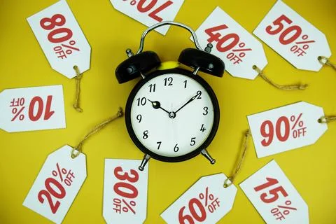 Clock surrounded by various discount tags with percentages like 10%, 20%, 3.. Foto stock