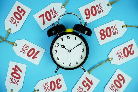Clock surrounded by various discount tags with percentages like 10%, 20%, 3.. Foto stock