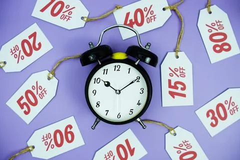 Clock surrounded by various discount tags with percentages like 10%, 20%, 3.. Foto stock