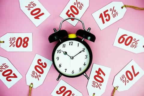 Clock surrounded by various discount tags with percentages like 10%, 20%, 3.. Foto stock