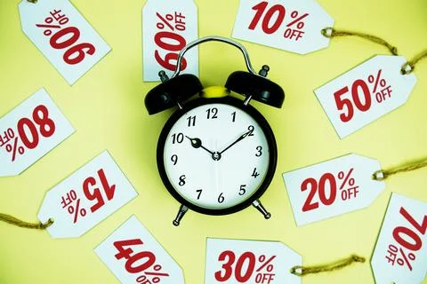 Clock surrounded by various discount tags with percentages like 10%, 20%, 3.. Foto stock