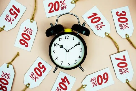 Clock surrounded by various discount tags with percentages like 10%, 20%, 3.. Foto stock