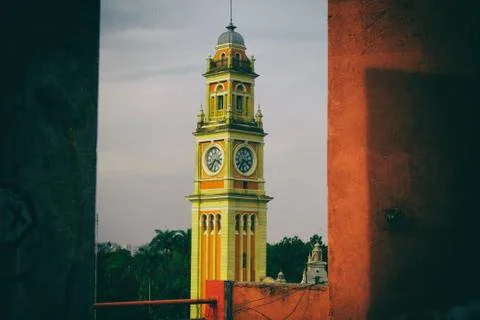 Clock tower behing red wall. Stock Photos