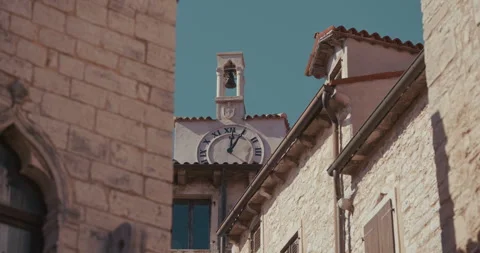 Clock tower with bell between stone buildings in Bale Vídeo Stock 334032501