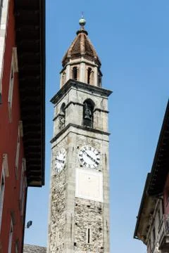 Clock tower of Chiesa Parrocchiale dei Santi Pietro e Paolo at center square in Stock Photos