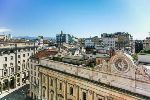 A clock tower with a clock on it is in the middle of a Milano city Italy Stock Photos