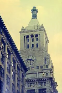 Clock tower with a clock. The tower is tall and has a dome on top. Stock Photos