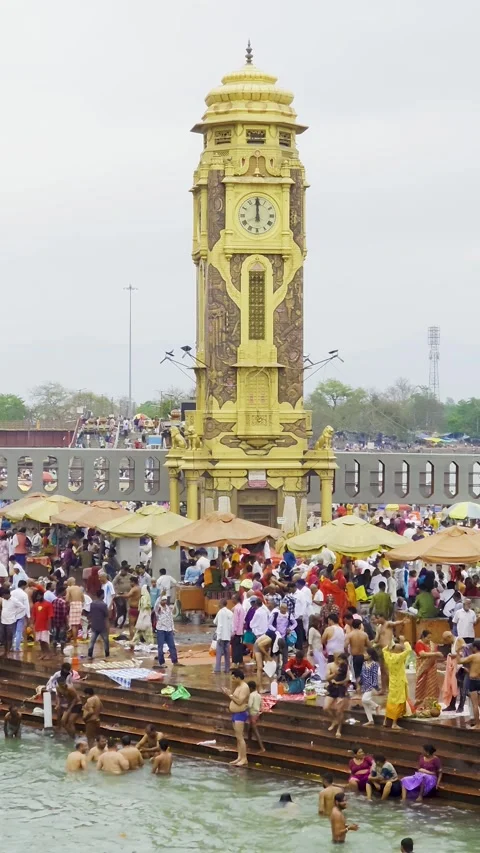Clock tower at Har ki pauri river ghat bank near the holy ganga river with crowd Stock Footage 331253493