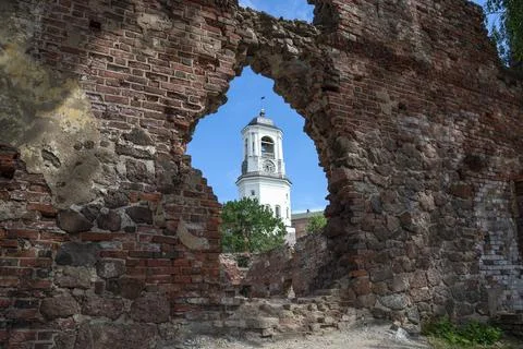 The clock tower in the opening of the wall of the old cathedral. Vyborg Stock Photos