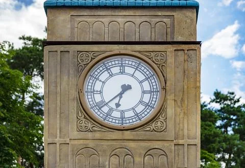 The clock on the tower. Round dial of the  clock on the background of the s.. Stock Photos