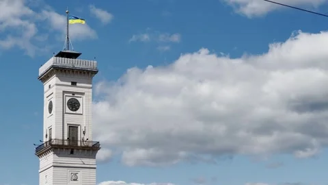 Clock tower with Ukrainian flag against a cloudy sky Stock Footage 314294770