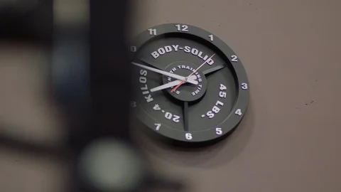 Clock on a wall that looks like a weight Stock Footage 106588819