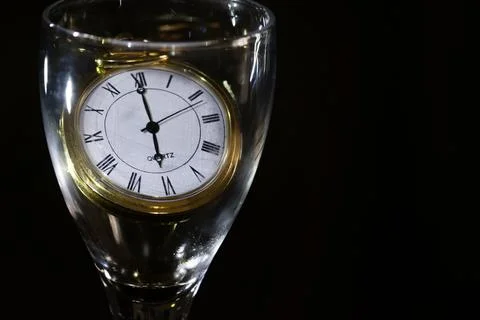 Clock watch inside glass on dark background Stock Photos