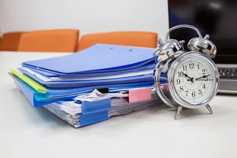Clock on work desk with docutment background in the office Stock Photos