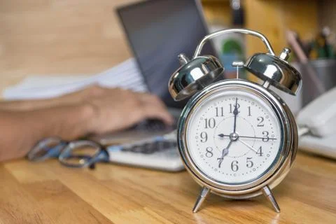 Clock on work desk  in the work office Time of working concepts office life 스톡 사진