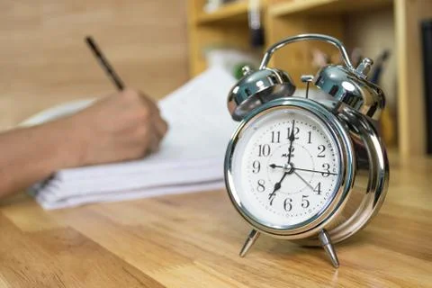 Clock on work desk  in the work office Time of working Stock Photos