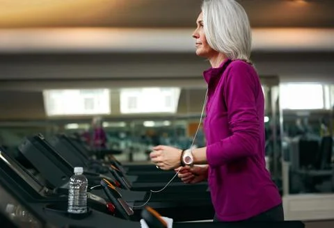 Clocking some miles on the treadmill. a mature woman exercising on a treadmill Stock Photos