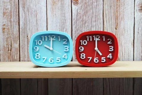 Clocks with time zone of different country on wooden shelves background Foto stock
