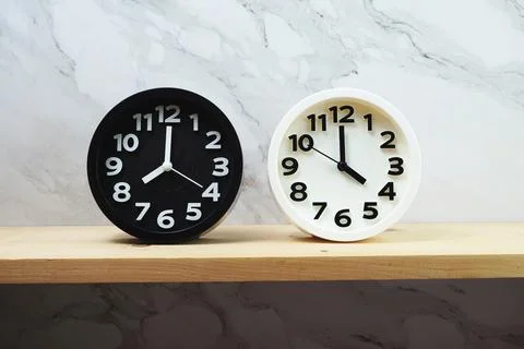 Clocks with time zone of different country on wooden shelves and marble backg Stock Photos