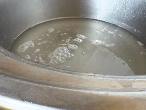A clogged pipe under the sink leads to a delayed flow of water, causing Stock Photos