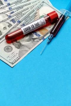 Close up 100 US dollar bills and blood sample in test tube over blue background Foto stock