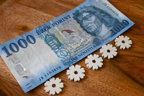 Close-up of a 1000 forint banknote on a table decorated with spring flowers, sym Stockfoto's