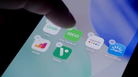 Close-up of the 12Go app being deleted from a smartphone home screen in a dark Stock Footage 337240067